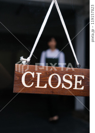 カフェの開店で看板をひっくり返す若い女性店員 119157823