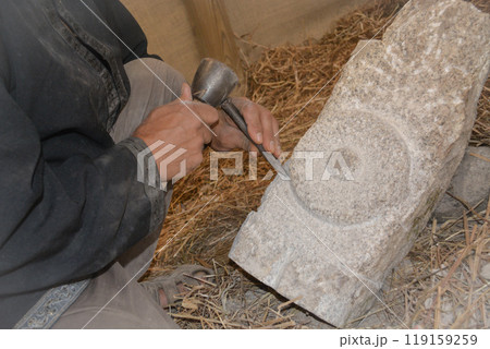 Hands of a master mason at a medieval festival in Portugal, working with stone using tools. Concept for reconstructing historical crafts Hands of a master mason at a medieval festival in Portugal, working with stone using tools. Concept for reconstructing historical crafts 119159259