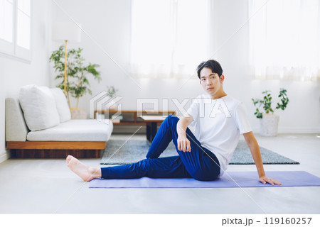 自宅のリビングでストレッチをする男性 自宅のリビングでストレッチをする男性 119160257