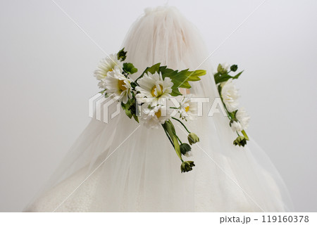 tulle fabric embroidery of flowers and birds on a veil On a thin fabric a woman embroiders straightening beautiful handwork on a mannequin wedding dress with bright decorations 119160378
