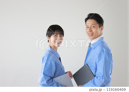 作業服を着たスタッフ男女_デバイスを持ち振り返る_2 119160409