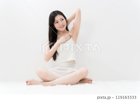 ビューティー　胡座をかいて脇の下を気にしている若い女性　脱毛　 119163333