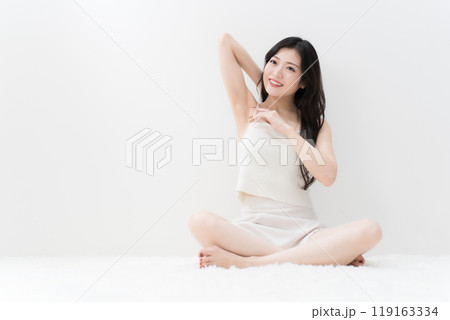 ビューティー　胡座をかいて脇の下を気にしている若い女性　脱毛　 119163334
