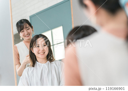 美容室・ヘアサロンで髪型を相談するアジア人女性の客とカウンセリングする美容師・スタイリスト 美容室・ヘアサロンで髪型を相談するアジア人女性の客とカウンセリングする美容師・スタイリスト 119166901