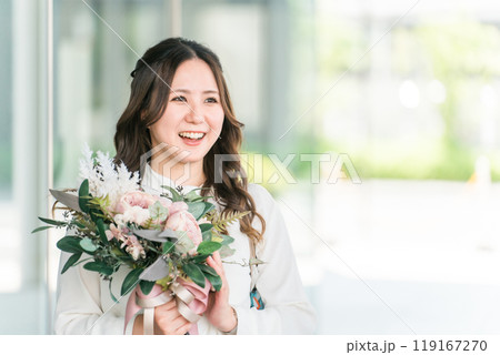 送別会・歓迎会・育休で同僚から花束をもらう若いビジネスウーマン 119167270