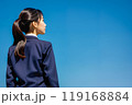 青空と学校の制服を着た女の子の後姿。 119168884