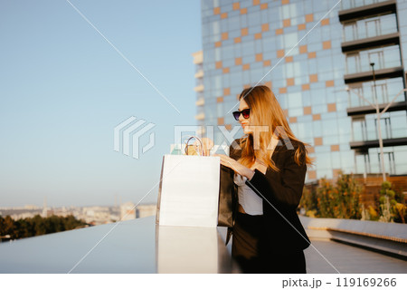 Woman Shopping Outdoors in Cityscape Woman Shopping Outdoors in Cityscape 119169266