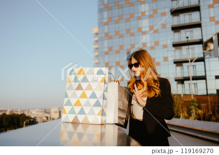 Woman Shopping Outdoors with Gift Bags Woman Shopping Outdoors with Gift Bags 119169270