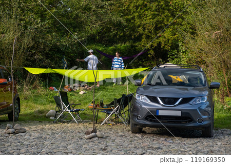 Camping Setup by the Riverbank with Cars Camping Setup by the Riverbank with Cars 119169350