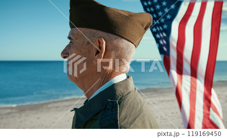 United States Navy Veteran Is Moved Looking At The Ocean With American Flag United States Navy Veteran Is Moved Looking At The Ocean With American Flag 119169450