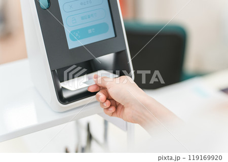 薬局・病院でマイナンバーカードをカードリーダーの機械で読み込む女性 119169920