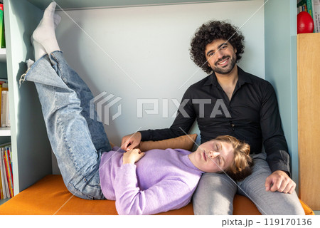 Enjoying a relaxed time at home, a couple is spending a casual moment together on a sofa Enjoying a relaxed time at home, a couple is spending a casual moment together on a sofa 119170136
