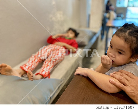 Asian children sleep on the bed in a coffee shop. 119171607