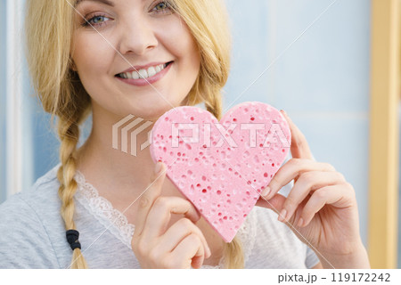 Blonde woman in braids holding heart 119172242