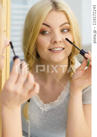 Woman using mascara on her eyelashes 119172245