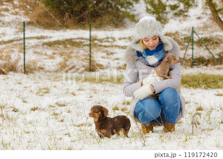 Woman playing with dogs during winter Woman playing with dogs during winter 119172420