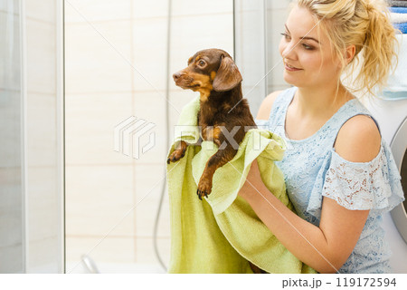 Woman drying dog after bath 119172594