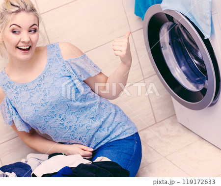 Happy woman washing laundry. 119172633