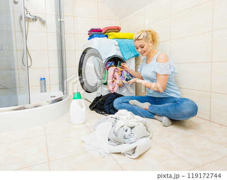 Woman wash laundry using detergent pods Woman wash laundry using detergent pods 119172744