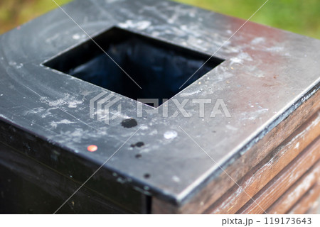 A wooden trash can containing a black garbage bag inside it A wooden trash can containing a black garbage bag inside it 119173643