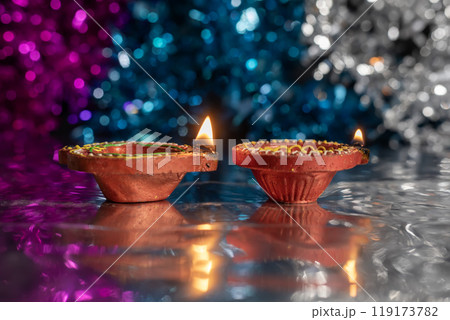 Close-up of two beautifully decorated diyas during Diwali on bokeh background. 119173782