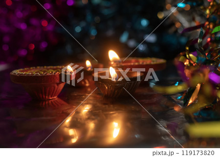 Diwali celebration background with glowing clay lamps and colorful lights. Diwali celebration background with glowing clay lamps and colorful lights. 119173820