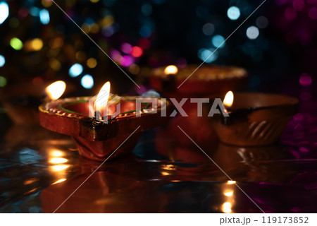 Traditional clay oil lamp lit with bokeh background. 119173852