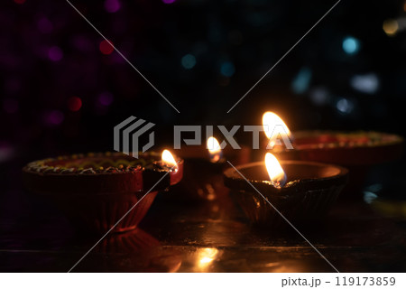 Traditional Diwali diyas with bokeh effects on dark background Traditional Diwali diyas with bokeh effects on dark background 119173859