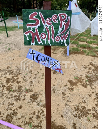 ハロウィンの屋外装飾 手書きの看板「SLEEPY HOLLOW」と秋のガーデンディスプレイ 119174744