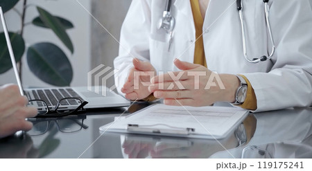 Doctor and patient consultation with clipboard and medication notes. Close-up view of unknown female doctor using a tablet during a patient consultation 119175241