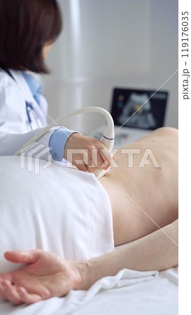 Doctor performing ultrasound examination on patient's back Doctor performing ultrasound examination on patient's back 119176035