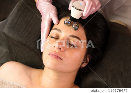 Client enjoys relaxing microcurrent forehead massage Client enjoys relaxing microcurrent forehead massage 119176475