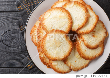 Almond tuiles Tejas de almendras, roof tile shaped almond pastry closeup on the plate. Horizontal top view 119177134
