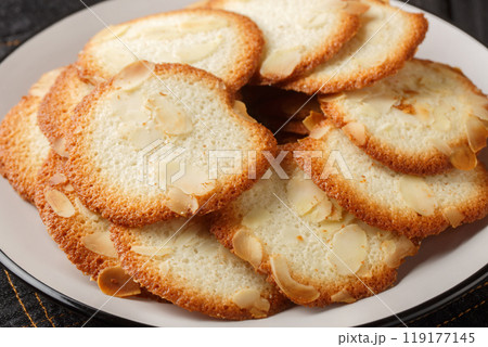 Almond tuiles are baked wafers, thin, crisp and sweet with almond closeup on the plate. Horizontal Almond tuiles are baked wafers, thin, crisp and sweet with almond closeup on the plate. Horizontal 119177145