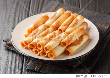 French sweet thin wafer tubes called Russian cigarettes close-up in a plate. Horizontal French sweet thin wafer tubes called Russian cigarettes close-up in a plate. Horizontal 119177158