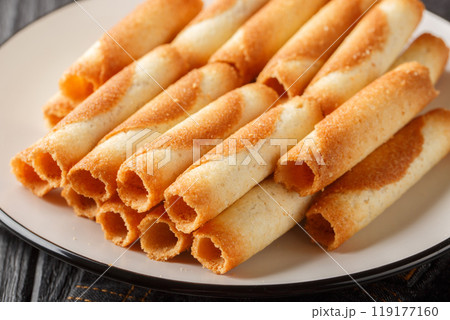 Cigarettes russes or russian cigarettes is a baked thin waffle rolls closeup on the plate. Horizontal 119177160