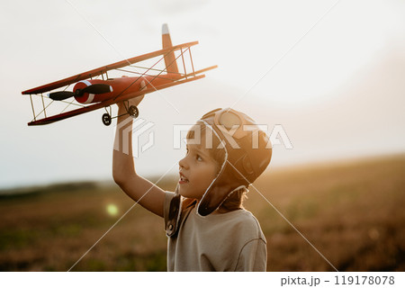 Handsome child boy running with wooden airplane. Kid dreaming to be pilot. Handsome child boy running with wooden airplane. Kid dreaming to be pilot. 119178078
