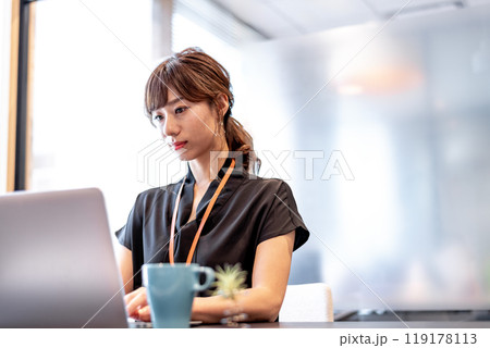 真剣な表情でパソコン作業をする女性 119178113