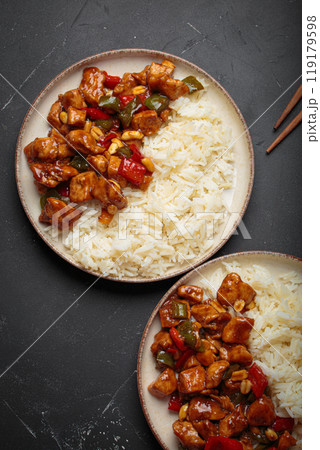 Kung pao chicken with peanuts and rice on a two plates top view, traditional Chinese cuisine 119179598