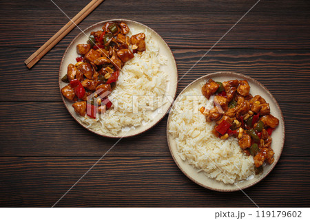 Kung pao chicken with peanuts and rice on two plates top view, traditional Chinese cuisine Kung pao chicken with peanuts and rice on two plates top view, traditional Chinese cuisine 119179602
