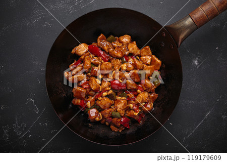 Traditional Chinese dish kung pao chicken in wok pan on dark background top view 119179609