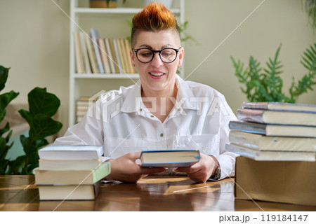 Woman with new books unpacked from cardboard box Woman with new books unpacked from cardboard box 119184147