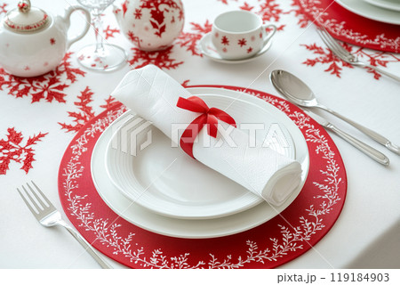Christmas dinner table set with gold ornaments, fir branches, and festive dinnerware on a white background 119184903