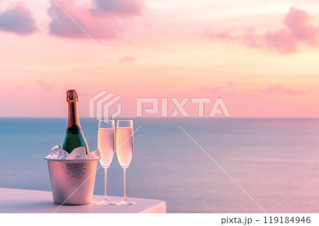 Champagne bottle in an ice bucket with two glasses at seaside view. Soft colors and serene background evoke celebration 119184946
