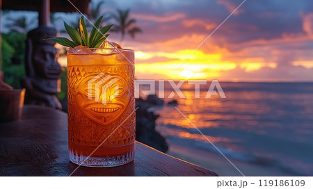 Mai Tai with a backdrop of Polynesian tiki statues and a Pacific island sunset. 119186109