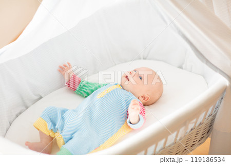 Cute baby boy in a white crib Cute baby boy in a white crib 119186534