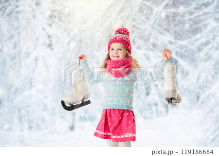 Little girl having fun at ice skating in winter 119186684