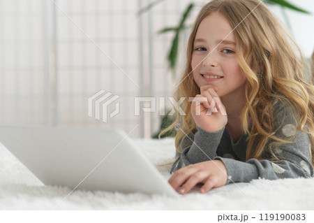girl in the nursery draws lying on the carpet. girl in the nursery draws lying on the carpet. 119190083