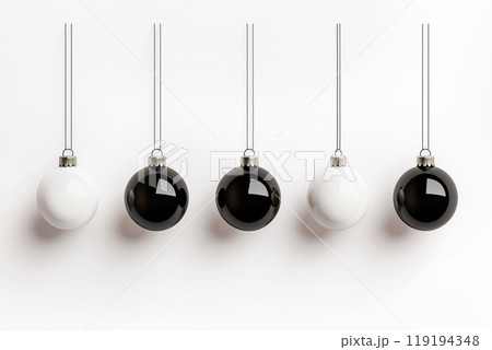 Glossy black and white ornaments suspended on thin strings on white background, showcasing a modern Christmas aesthetic Glossy black and white ornaments suspended on thin strings on white background, showcasing a modern Christmas aesthetic 119194348