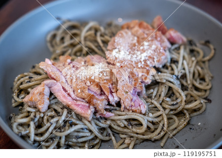 Spaghetti with truffle sauce, grilled meat on the top, served on plate 119195751